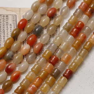 Macro detail of oval and bamboo shaped agate beads on vintage book pages in Oriental style