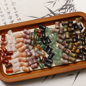 Macro detail of bamboo-shaped red agate and rose quartz beads on a Chinese style tray