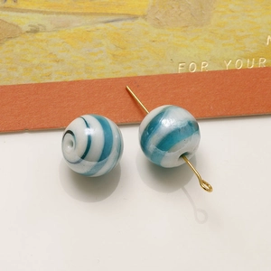 Dettaglio macro di perle in vetro lampwork da 12mm blu e bianche per gioielli fai-da-te