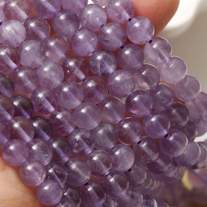 Makro-Detail von 8mm Amethyst-Rundperlen mit natürlichen Eiskristall-Texturen