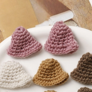Detailed view of handmade mini crochet hats in assorted colors for DIY crafts and dolls