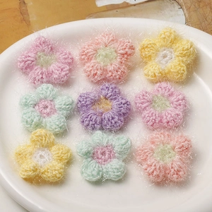 Makroaufnahme von 9 bunten handgehäkelten Puff-Blumen für DIY-Haarschmuck und Bastelarbeiten