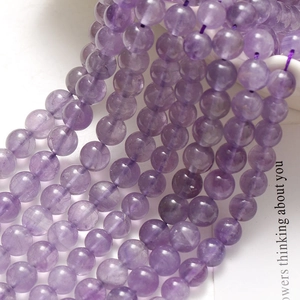 Nahaufnahme von 8mm Amethyst-Rundperlen mit hoher Transparenz und polierter Oberfläche
