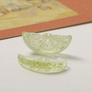 Detailed macro view of translucent light green resin lemon slice charms for DIY jewelry