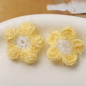 Makroaufnahme flauschiger gelber Häkelblumen mit Glitzergarn für DIY Haarschmuck Zubehör