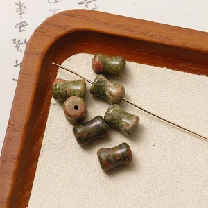Macro detail of dumbbell-shaped unakite natural stone beads with drill hole for jewelry DIY