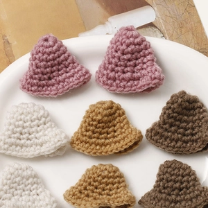 Macro detail of hand-crocheted mini bell ornaments in various pastel cotton colors