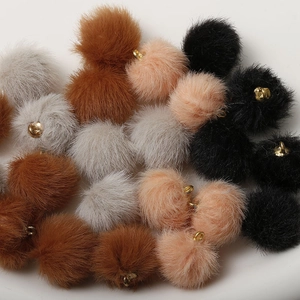 Detail of colorful plush fur balls with gold metal rings for DIY jewelry making