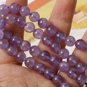 Makroaufnahme von 8mm Naturamethyst-Rundperlen mit einzigartigen Texturen und Schliff