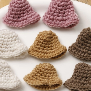 Close-up of mini crochet bucket hats in four colors for DIY craft and doll accessories