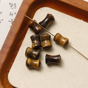 Macro detail of tiger eye stone beads with polished texture in a wooden tray