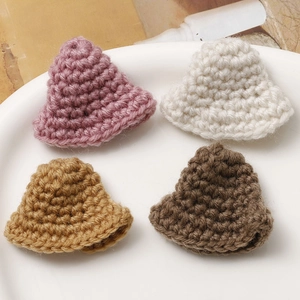Macro detail of four colorful handmade crochet mini hats for DIY hair accessories