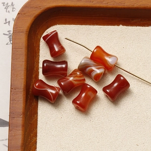 Macro shot of polished red agate hourglass-shaped loose beads for DIY jewelry making