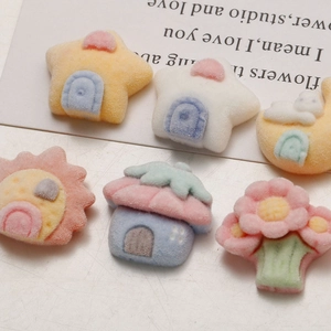 Macro detail of soft flocked resin charms in cute pastel star, house, and flower shapes