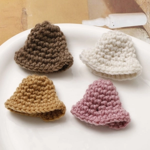Detailed macro view of four mini crochet bell hats in brown beige yellow and purple colors