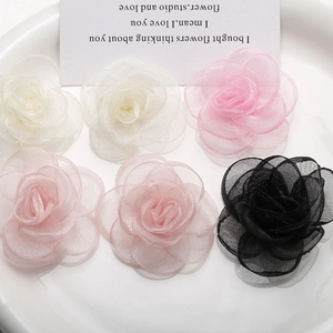 Detailed macro view of handmade organza rose flowers in white, pink and black colors