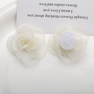 Handmade cream organza flower accessories showing front petals and felt backing base