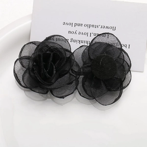 Detail view of handmade black mesh rose brooch with layered petals and felt base backing