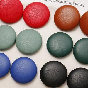 Detailed close-up of colorful leather buttons showing textured lychee grain and round design