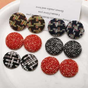 Close-up of assorted round tweed and houndstooth fabric buttons for DIY hair accessories