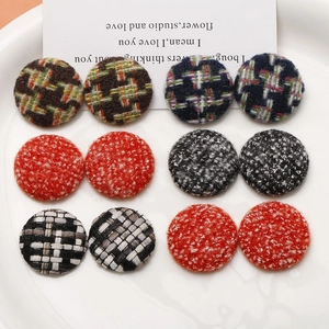 Detail of assorted tweed and houndstooth fabric covered round buttons for DIY crafts