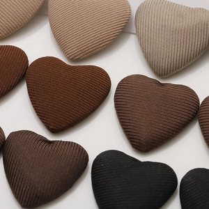 Detailed close-up of heart-shaped fabric buttons showing fine twill texture and earth tones
