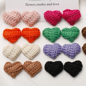 Close-up of colorful knitted heart-shaped patches with crochet texture for DIY crafts