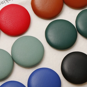 Close-up of colorful round leather buttons with lychee texture for DIY hair accessories