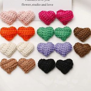 Macro shot of colorful heart-shaped knitted fabric charms for DIY hair accessories