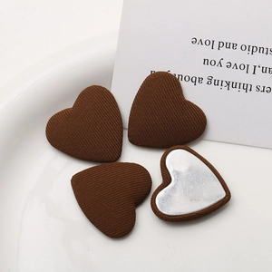 Detailed close-up of dark brown fabric heart buttons with silver metal backing