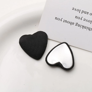 Detailed view of heart-shaped black ribbed fabric buttons with flat silver metal backings