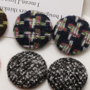 Close-up of retro fabric covered round buttons in navy tweed and black white wool textures