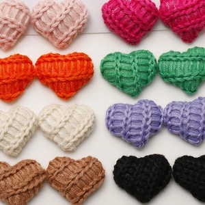 Macro detail of colorful knitted heart-shaped charms with 3D woven texture for DIY crafts
