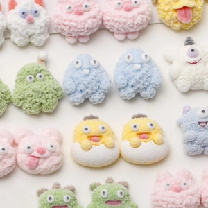 Macro detail of various colorful flocked mini monster resin charms with soft velvet texture