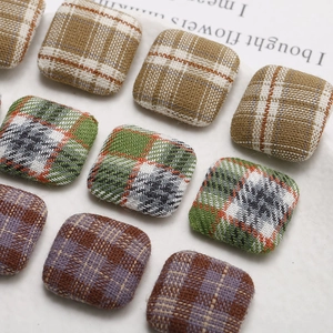 Macro view of retro checkered fabric square buttons for DIY jewelry making and accessories