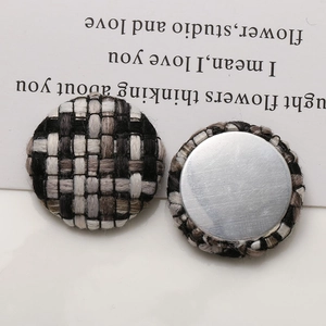 Macro detail of round tweed fabric buttons with metallic backing for DIY hair accessories