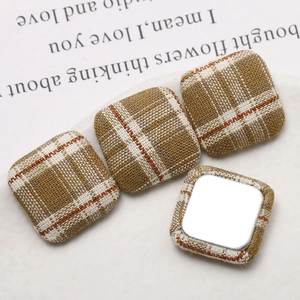 Macro shot of brown plaid fabric square flatback buttons for DIY earring accessories