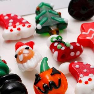 Vista macro di perline di vetro a lume fatte a mano a forma di Babbo Natale e zucca