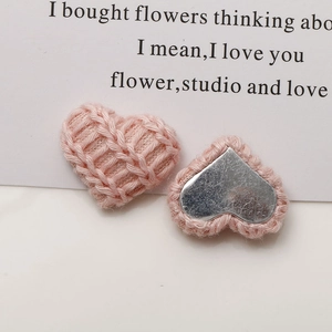 Close-up of pink knitted heart decorative buttons with silver metal backing for DIY crafts