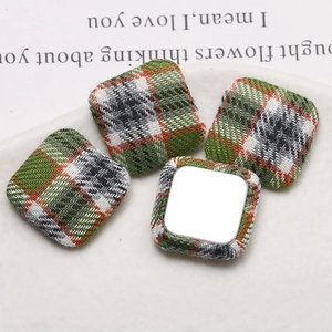 Macro detail of plaid fabric square buttons showing textile texture and metal flat back base