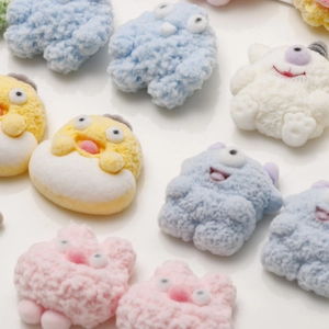 Detailed macro view of colorful flocked cartoon monster resin charms with fiber texture