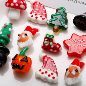 Macro di ciondoli festivi in vetro colorato per Natale e Halloween su sfondo bianco