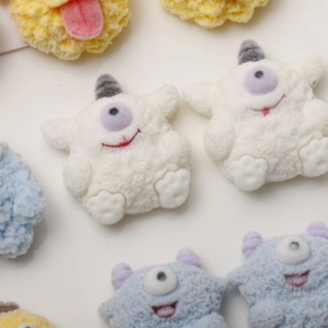 Close-up of colorful flocked monster DIY accessories with soft textures and cute expressions