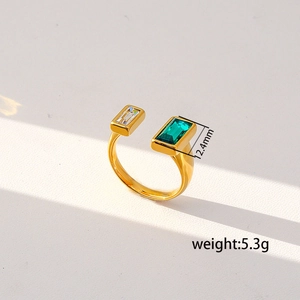 Detail of adjustable gold ring featuring emerald green and white zircon gemstones