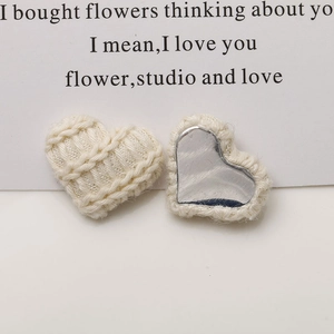 Close-up of knit heart-shaped DIY accessory with soft braided texture and silver mirror back