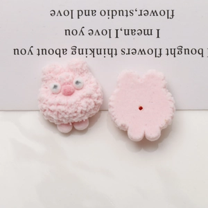 Detail of pink flocked dog charms showing flat back and central hole for DIY assembly