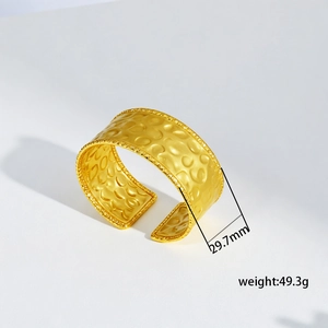 Detailed view of 29.7mm wide gold titanium cuff bracelet with hammered honeycomb texture
