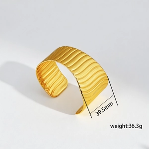 Detailed view of 39.5mm wide gold titanium cuff bracelet with wave texture and size specs