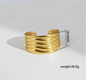 Detail showing wave textured gold bangle with 30.6mm width and 30.9g weight specifications