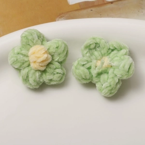 Detailed view of handmade green and yellow plush puff flowers for DIY jewelry making